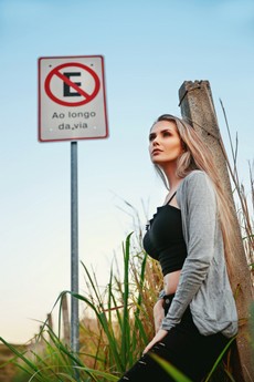 photo-of-woman-leaning-against-a-concrete-post-beside-a-road-2661538.jpg