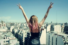woman-standing-on-rooftop-putting-hands-in-the-air-under-816233.jpg