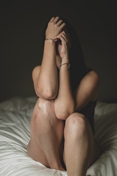 woman-covering-face-through-hands-sitting-on-bed-1922220.jpg