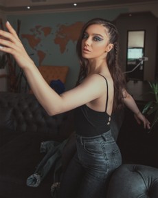 photo-of-woman-in-black-tank-top-and-jeans-sitting-on-arm-of-3085936.jpg